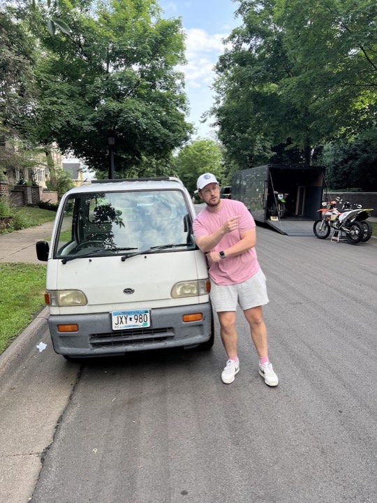 Jeremy Vandehey standing beside the kei truck, pointing at it.
